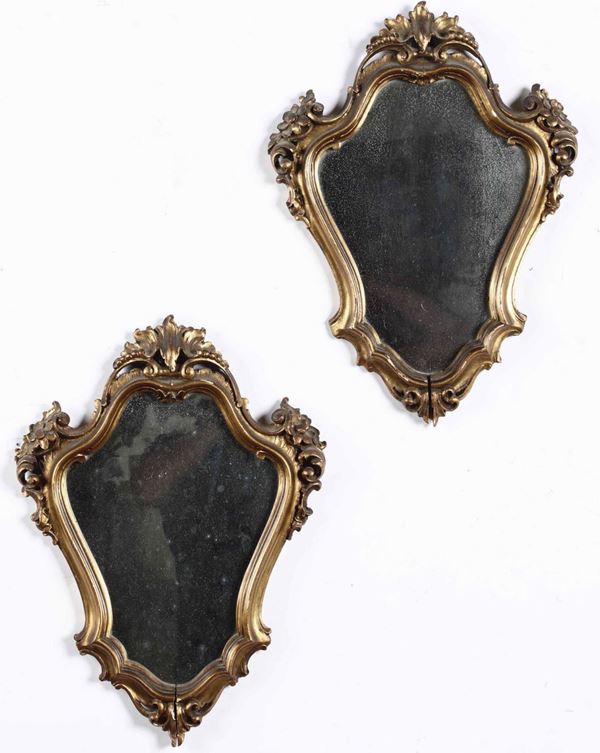 Coppia di specchiere in stile in legno intagliato e dorato, XX secolo