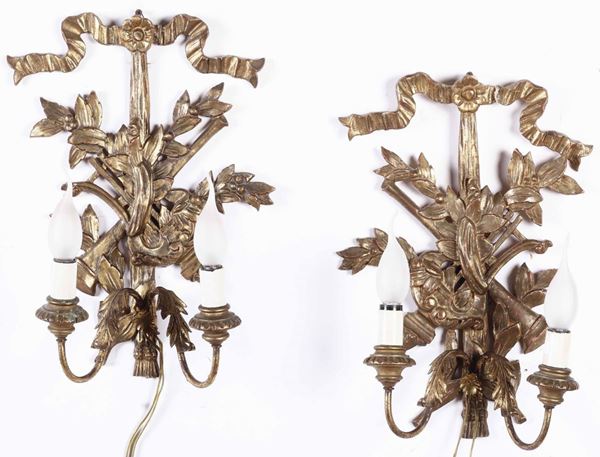 Coppia di appliques dorate a due luci intagliate a trionfo musicale e nodo d'amore, XIX-XX secolo