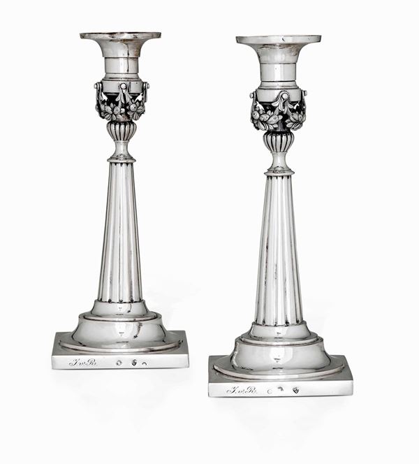 Coppia di candelieri in argento fuso, sbalzato e cesellato. Germania XIX secolo