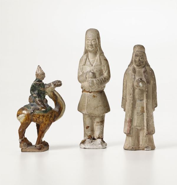 Lotto composto da coppia di guerrieri in terracotta e personaggio su cammello in terracotta invetriata, Cina, Dinastia Tang (618-906)
