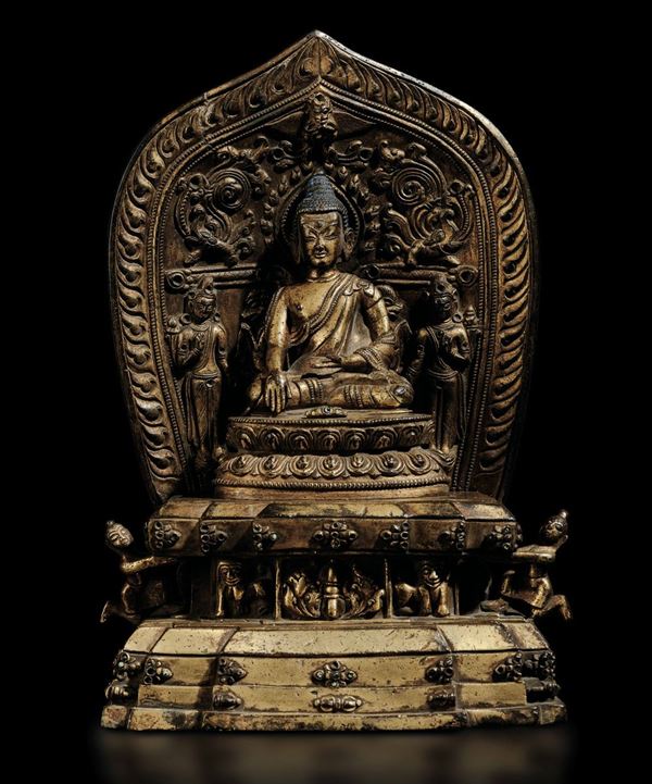 Rara scultura raffigurante Buddha Sakyamuni seduto su doppio fiore di loto entro aura con offerenti in bronzo dorato, tracce di policromia e innesti di turchese, Tibet, XV/XVI secolo