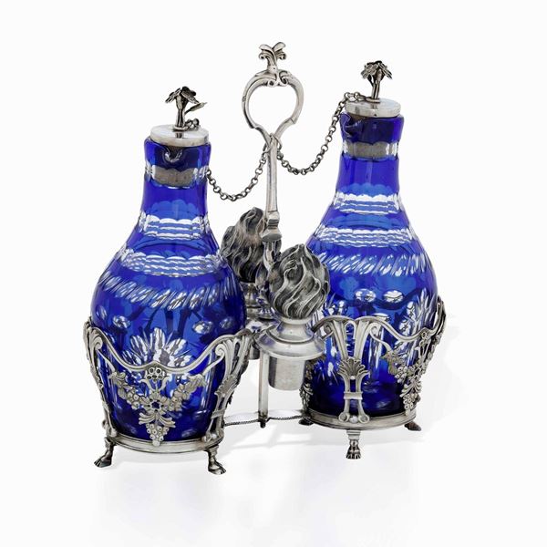 Oliera in argento fuso, sbalzato e cesellato con bottiglie in vetro blu molato. Belgio XVIII secolo (?)