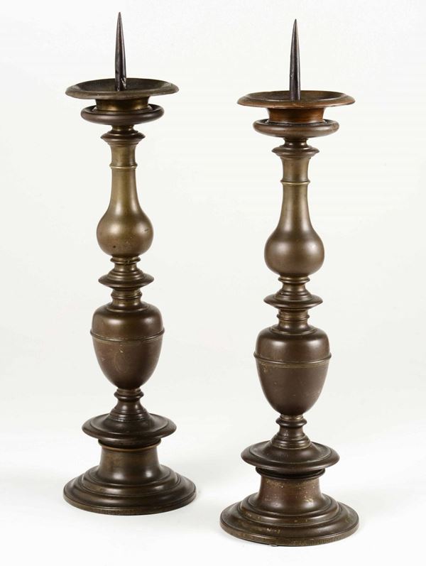 Coppia di candelieri a balaustro in bronzo fuso. Fonditore del XVII-XVIII secolo
