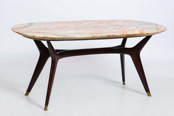 Tavolo ovale con struttura e sostegni in legno, piano in marmo e particolari in ottone.