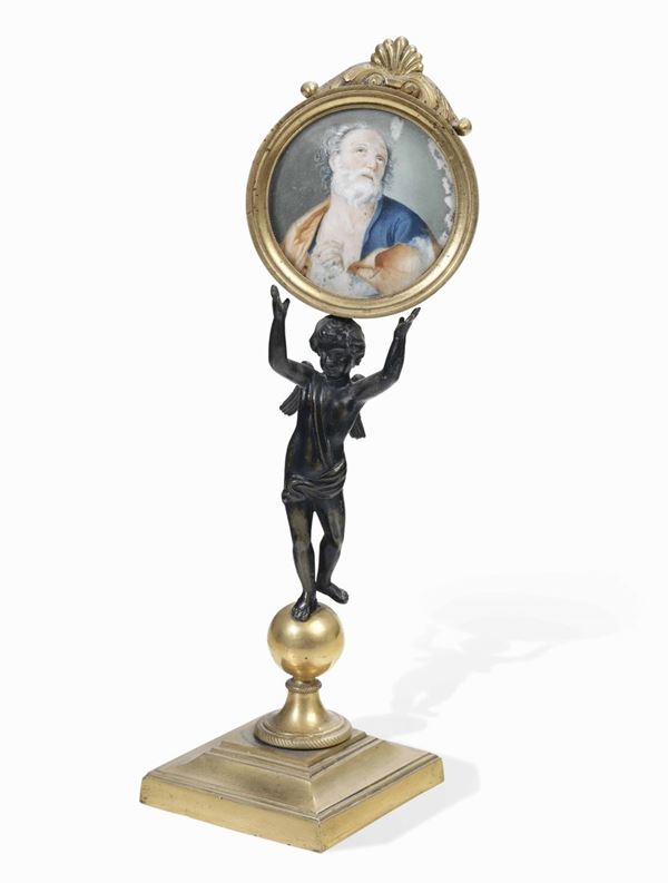 Putto in bronzo che sorregge cornice in legno dorato contenente miniatura di San Giuseppe. XVIII-XIX secolo