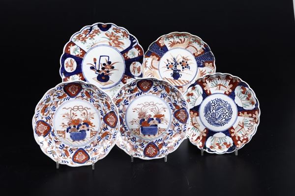 Cinque piatti diversi in porcellana Imari con decori floreali e naturalistici, Cina, XIX secolo