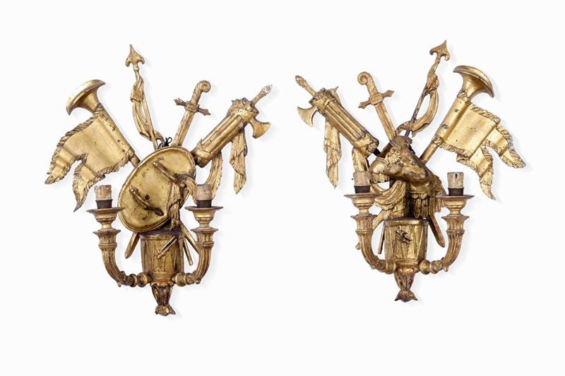 Coppia di appliques a due bracci in legno intagliato e dorato con panoplie, XVIII secolo  - Asta Importanti Opere e Arredi - Cambi Casa d'Aste