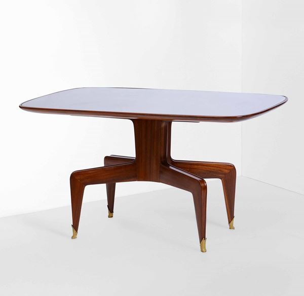 Tavolo con struttura e sostegni in legno, piano in vetro e particolari in ottone.