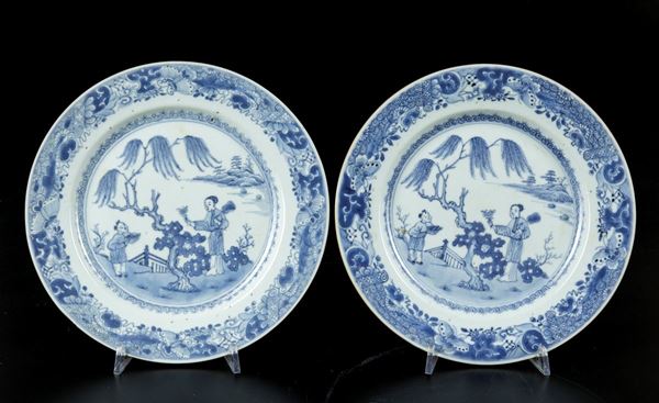 Coppia di piatti in porcellana bianca e blu con scena di vita comune e decori floreali, Cina, Dinastia Qing, epoca Qianlong (1736-1796)