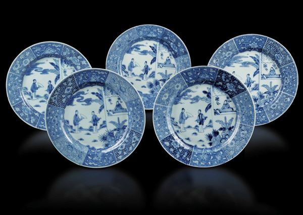 Cinque piatti in porcellana bianca e blu con scene di vita comune e decori floreali, Cina, Dinastia Qing, epoca Kangxi (1662-1722)