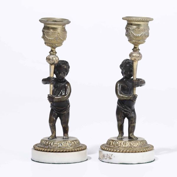 Coppia di candelieri in bronzo brunito e dorato con putti, XIX secolo