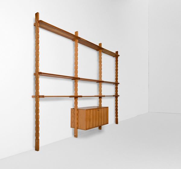 Libreria modulare a parete con mobile contenitore e quattordici mensole in legno.