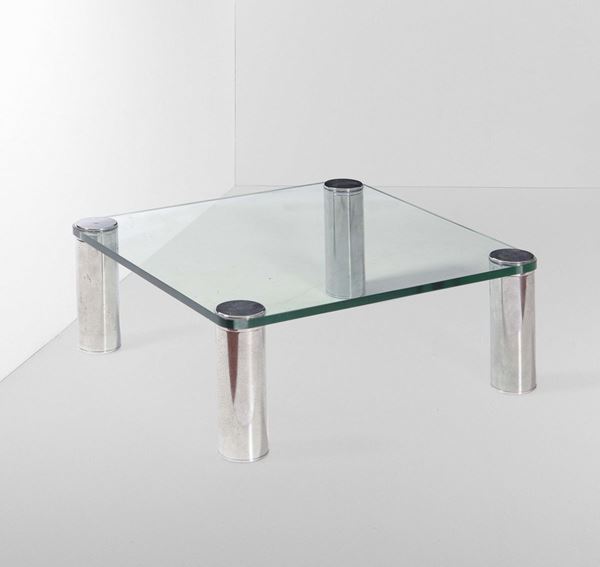 Tavolo basso con sostegni in metallo cromato e piano in vetro molato.