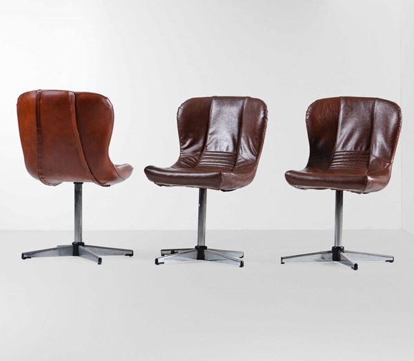 Tre sedie girevoli con struttura in legno, sostegni in metallo cromato e rivestimento in pelle.