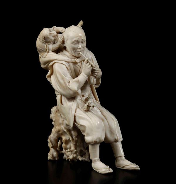A carved ivory figure, Japan, Meiji period (1868-1912). A musician with a monkey.