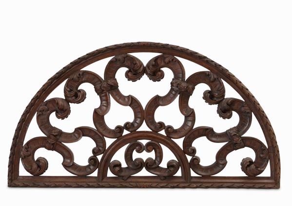 Lunetta sovrapporta in legno intagliato a volute