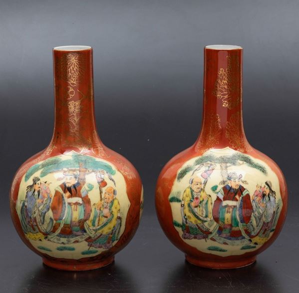 Coppia di vasi a bottiglia in porcellana a smalti policromi con figure di saggi entro riserve e decori floreali lumeggiati in oro, Cina, XX secolo
