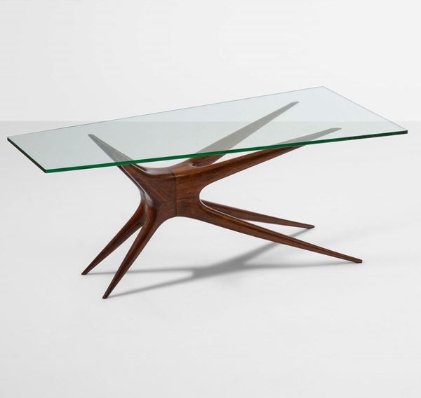 Tavolo basso con struttura in legno sagomato e scolpito, piano in cristallo molato.
