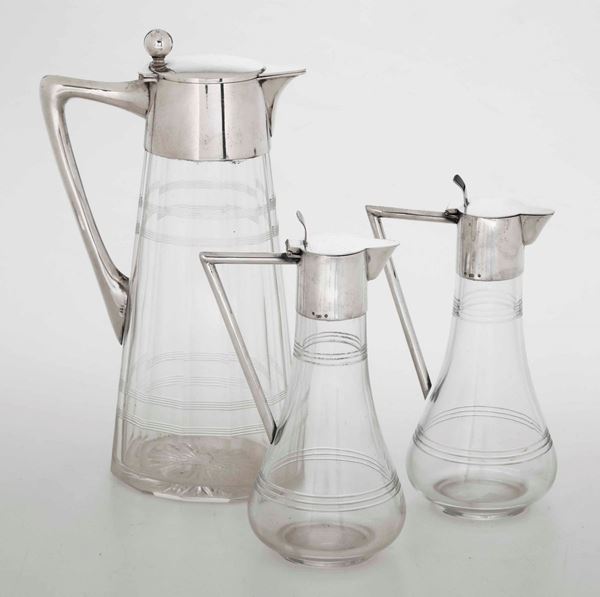 Tre bottiglie in vetro con montatura in argento. Argenteria europea del XX secolo