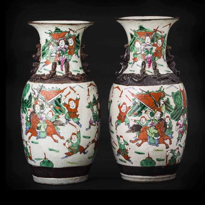 Coppia di vasi in porcellana con figure di draghetti a rilievo e  guerrieri, Cina, Dinastia Qing, XIX secolo  - Asta Chinese Works of Art - II - Cambi Casa d'Aste