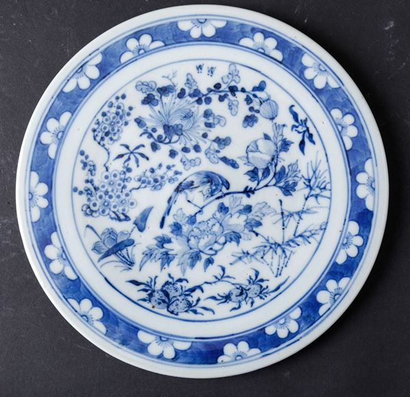 Piatto in porcellana bianca e blu con decori floreali e uccellino tra i rami, Cina, Dinastia Qing, XIX secolo