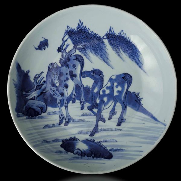 Piatto in porcellana bianca e blu raffigurante cavalli entro paesaggio, Cina, Dinastia Qing, XIX secolo