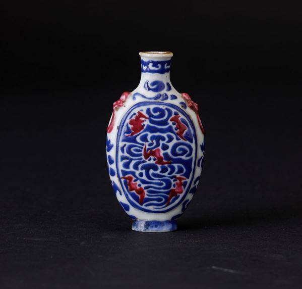 Snuff bottle in porcellana con decoro di pipidtrelli nei toni del blu e del rossao ferro, Cina, Dinastia Qing, XIX secolo