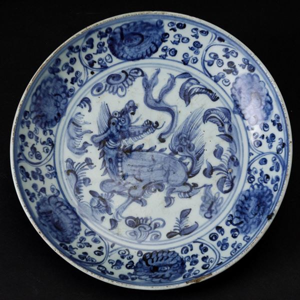 Piatto in porcellana bianca e blu con figura di drago centrale e decori floreali, Cina, Dinastia Qing, epoca Shunzhi (1644-1661)