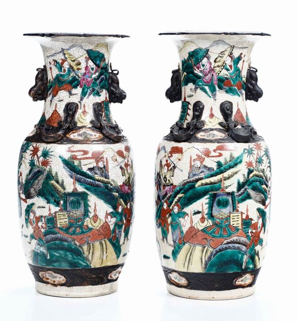 Coppia di vasi in porcellana raffiguranti paesaggi con cavalieri e figure di draghetti e leoncini a rilievo, Cina, Dinastia Qing, fine XIX secolo