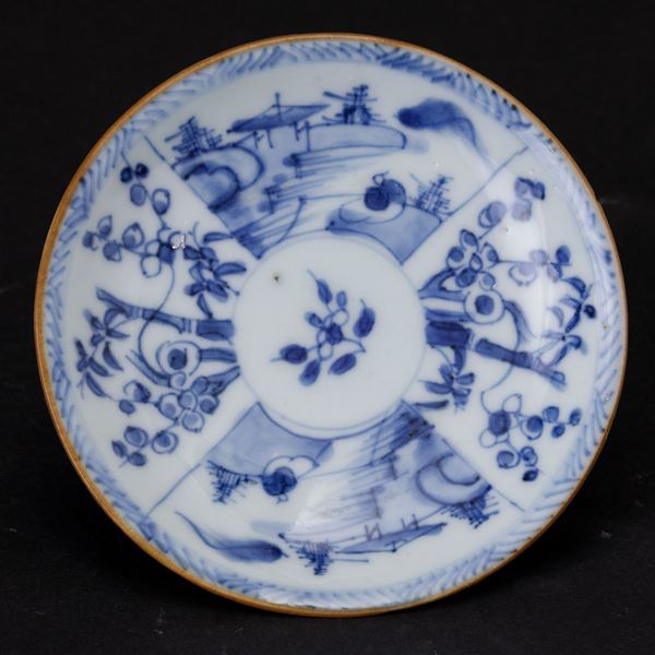Piccolo piatto in porcellana bianca e blu con raffigurazioni naturalistici e paesaggi entro riserve, Cina, Dinastia Qing, XIX secolo