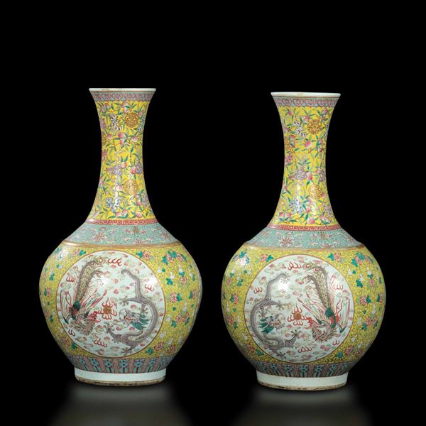 Coppia di grandi vasi a bottiglia in porcellana a smalti policromi con raffigurazione di draghi tra  [..]