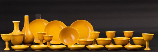 Servizio in porcellana monocroma gialla con decori incisi composto da cinque ciotole, due vasi di forme  [..]