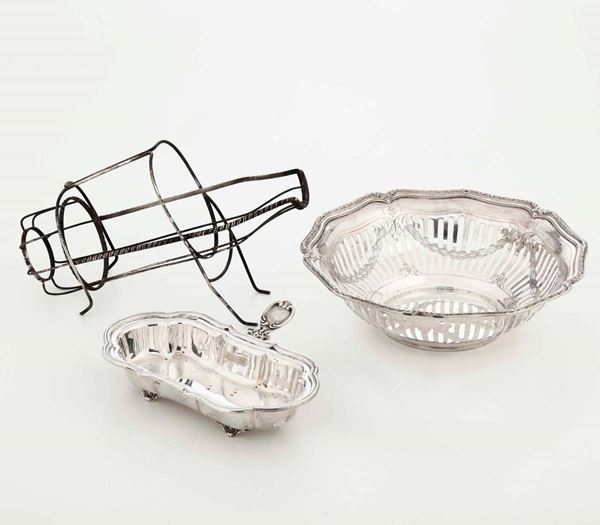 Lotto composto da una cestina, un porta bottiglie e vassoietto con manico in argento. Varie manifatture italiane del XX secolo