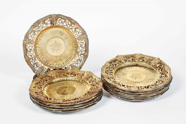 Set di dodici piatti. Argento fuso, sbalzato, traforato,cesellato e dorato. Inghilterra XIX secolo