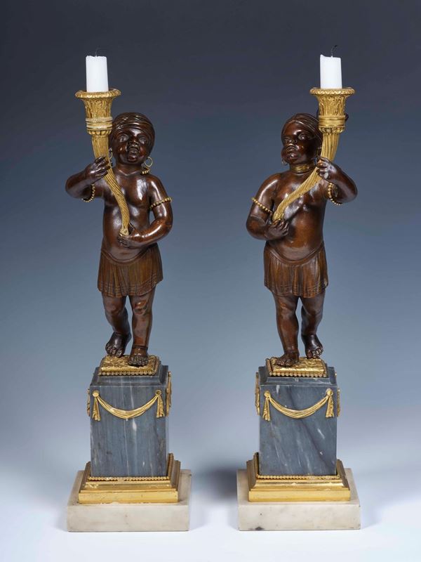 Coppia di rari candelieri in bronzo dorato e patinato. XVIII secolo