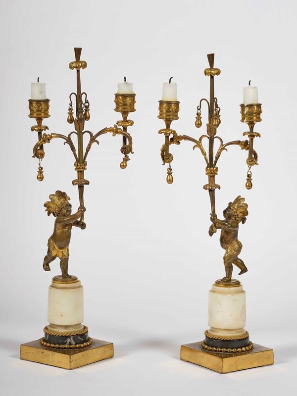 Coppia di candelabri a due fiamme in bronzo dorato e patinato. Francia, XIX secolo