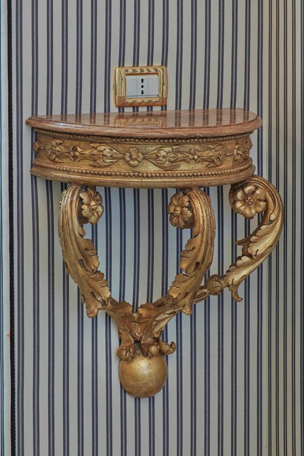 Coppia di piccole consolles pensili a demilune in legno intagliato e dorato. XIX secolo