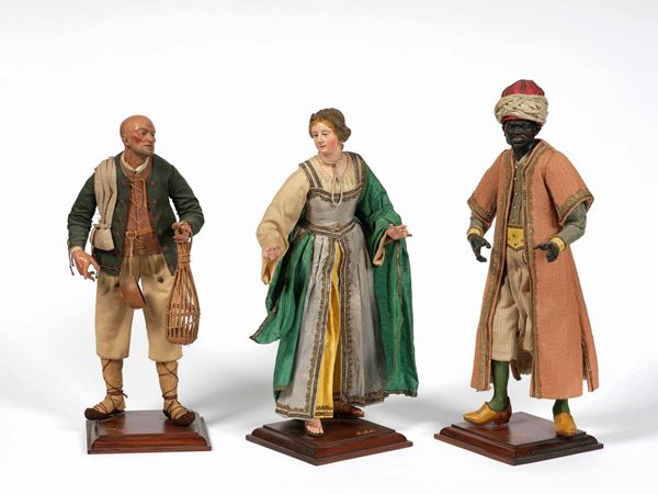Insieme di figure presepiali comprendente un venditore una giovane donna e un moro. Terracotta dipinta, vetro e stoffa. Arte napoletana del XX secolo