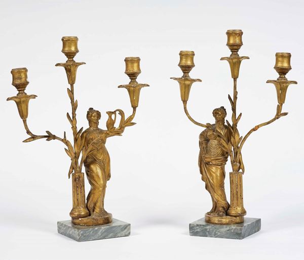 Coppia di candelabri a tre fiamme in legno intagliato e dorato. XVIII secolo