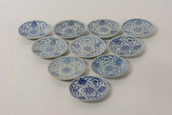 Lotto composto da sedici piatti diversi in porcellana bianca e blu con decori floreali e naturalistici, Cina, Dinastia Qing, XIX secolo