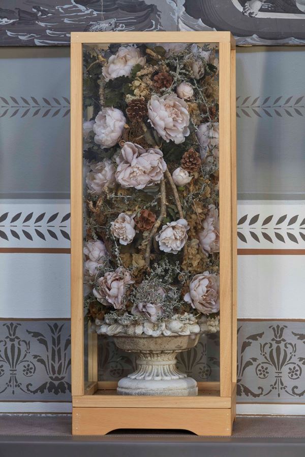 Coppia di teche contenenti composizioni di fiori entro vasi in pietra