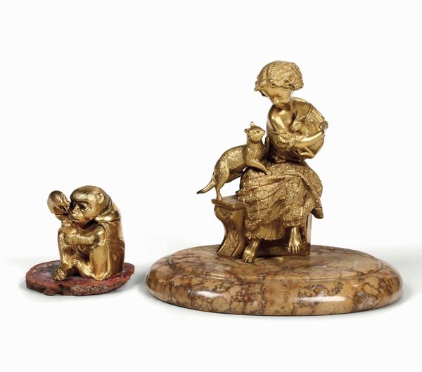 Lotto di due bronzetti dorati raffiguranti scimmietta e bimba con gatto e coniglio. Manifattura del XIX-XX secolo