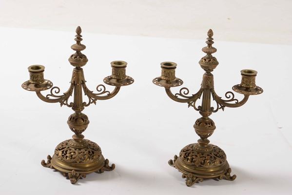 Coppia di doppieri in metallo dorato e traforato. XX secolo