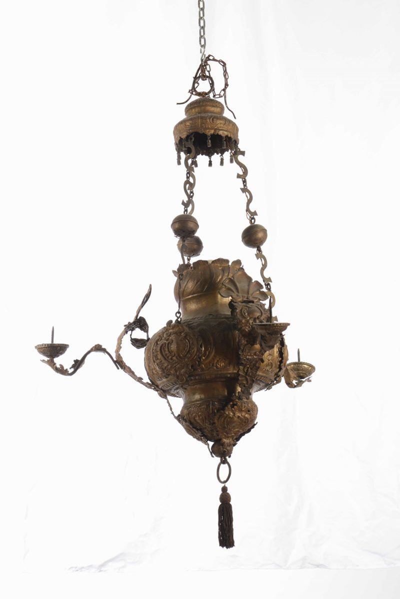 Grande lampada votiva in metallo sbalzato a tre luci  - Asta Una Proprietà Lombarda | Cambi Time - Cambi Casa d'Aste