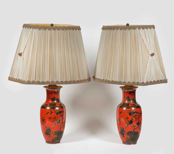 Coppia di vasi montati a lampada in porcellana a fondo rosso con soggetti naturalistici sui toni del nero e lumeggiati in oro, Cina, XX secolo