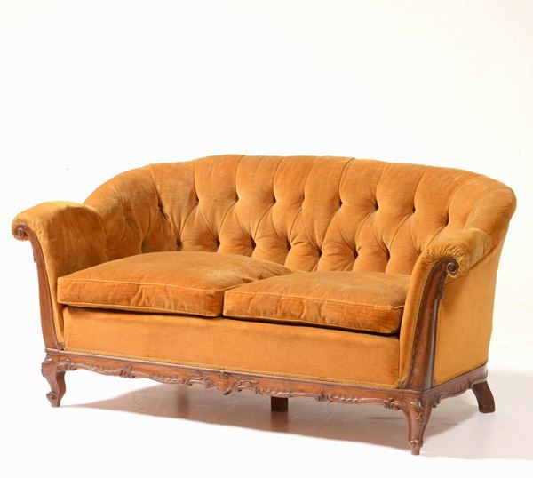 Un divano e due poltrone con struttura in legno intagliato e rivestiti in velluto ocra