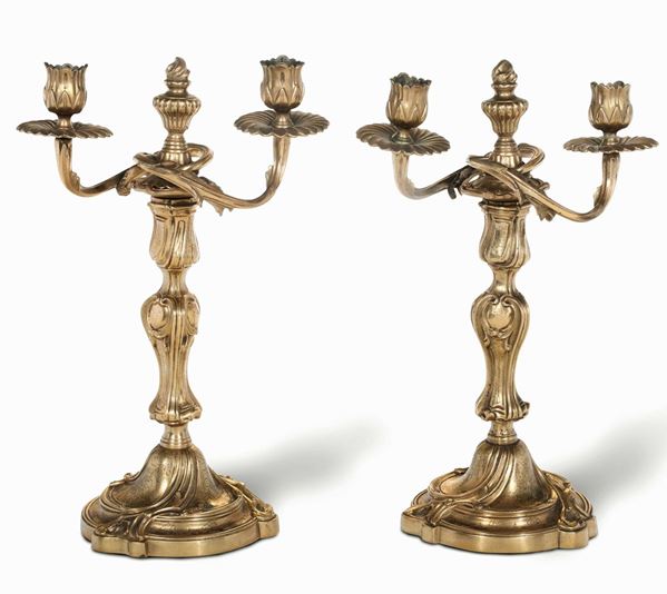 Coppia di doppieri a due luci in bronzo fuso e dorato. XIX-XX secolo