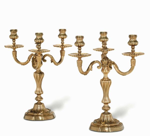 Coppia di candelabri a tre luci in bronzo fuso e dorato. XIX-XX secolo
