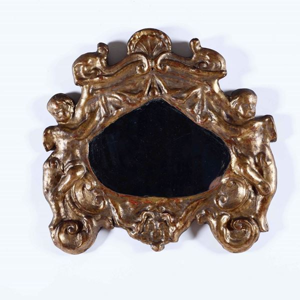 Piccolo specchio con cornice in legno intagliato e dorato. XVII secolo