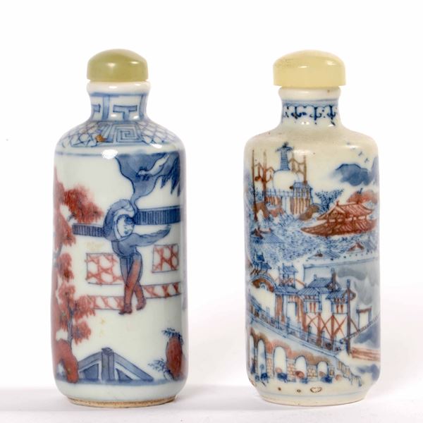 Due snuff bottles in porcellana raffiguranti scene di vita comune sui toni del blu e del rosso ferro, Cina, Dinastia Qing, XIX secolo